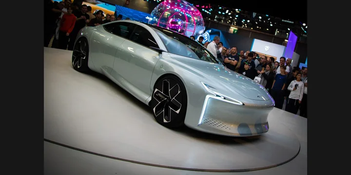 2022 Hopium Machina. Photograph by WikiGenesis, CC BY-SA 4.0. https://commons.wikimedia.org/wiki/File:Hopium_Machina_Vision_Mondial_de_l%27Automobile_Paris_2022_-_002_-_Concept-car_d%27Hopium_-_Prise_biais_2-4_Avant_-_Mod%C3%A8le_Hopium_Couleur_Blanche_-_France_-_0012.jpg Fit to 2:1 with dark side borders.